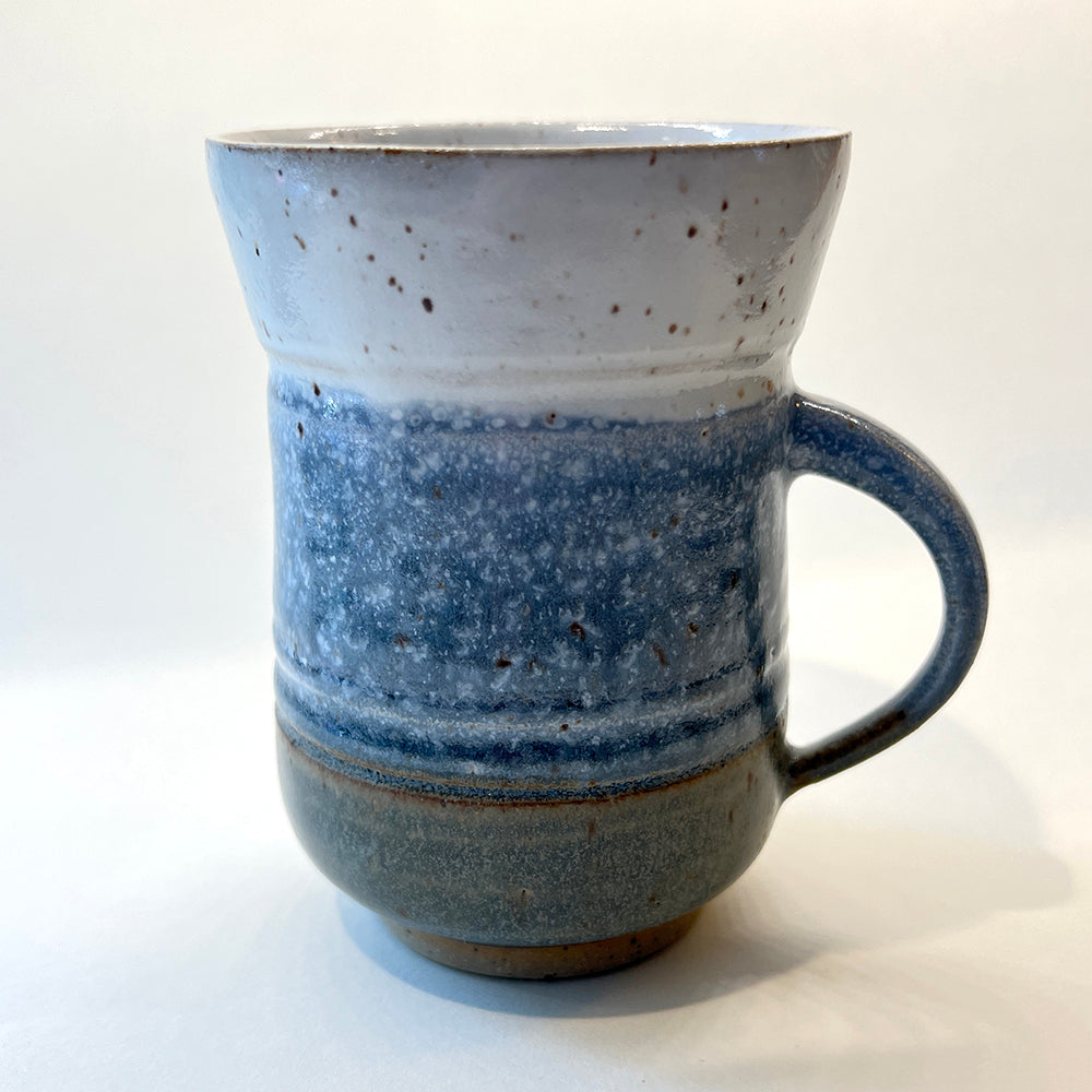 photo of the back of handmade pottery mug for the round pond getaway, with white, blue and grey glazes