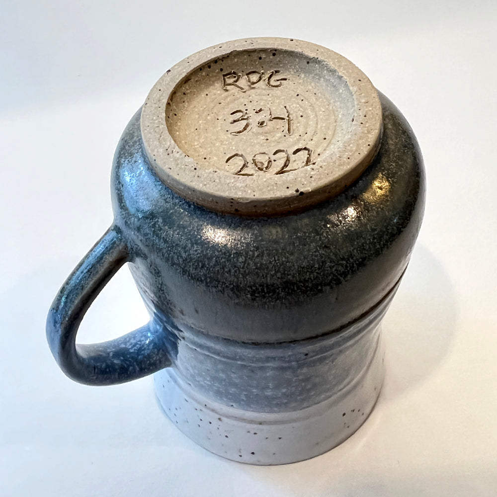 bottom view of photo of handmade pottery mug for the round pond getaway, with white, blue and grey glazes